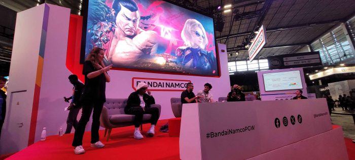 Photo de la scène Bandai Namco.
Sur la scène il y a trois commentateurs et une interprète en langue des signes française.
