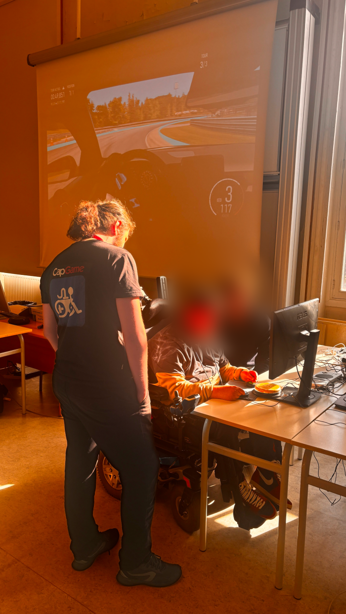 Sur la photo, il y a l'organisateur de la CapGame Arena qui accompagne un des joueurs sur le jeux Forza Motorsport.