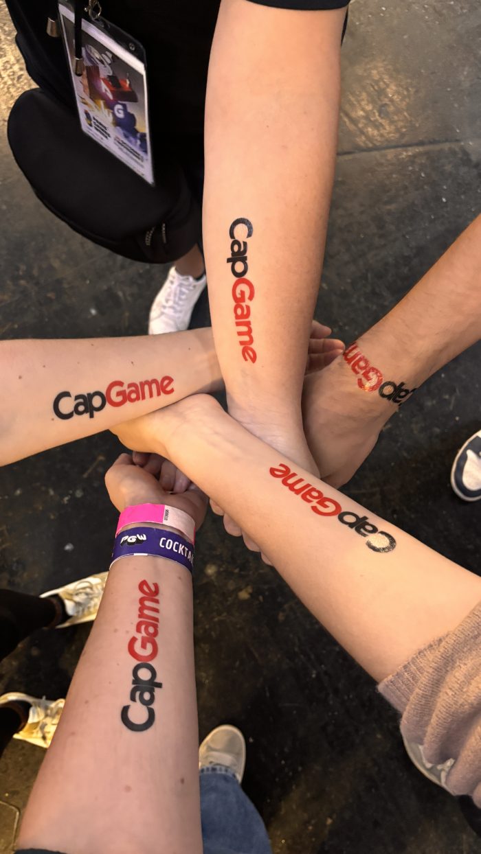 Les avants bras de 5 personnes présentant, sur chaque, un tatouage éphémère CapGame rouge et noir